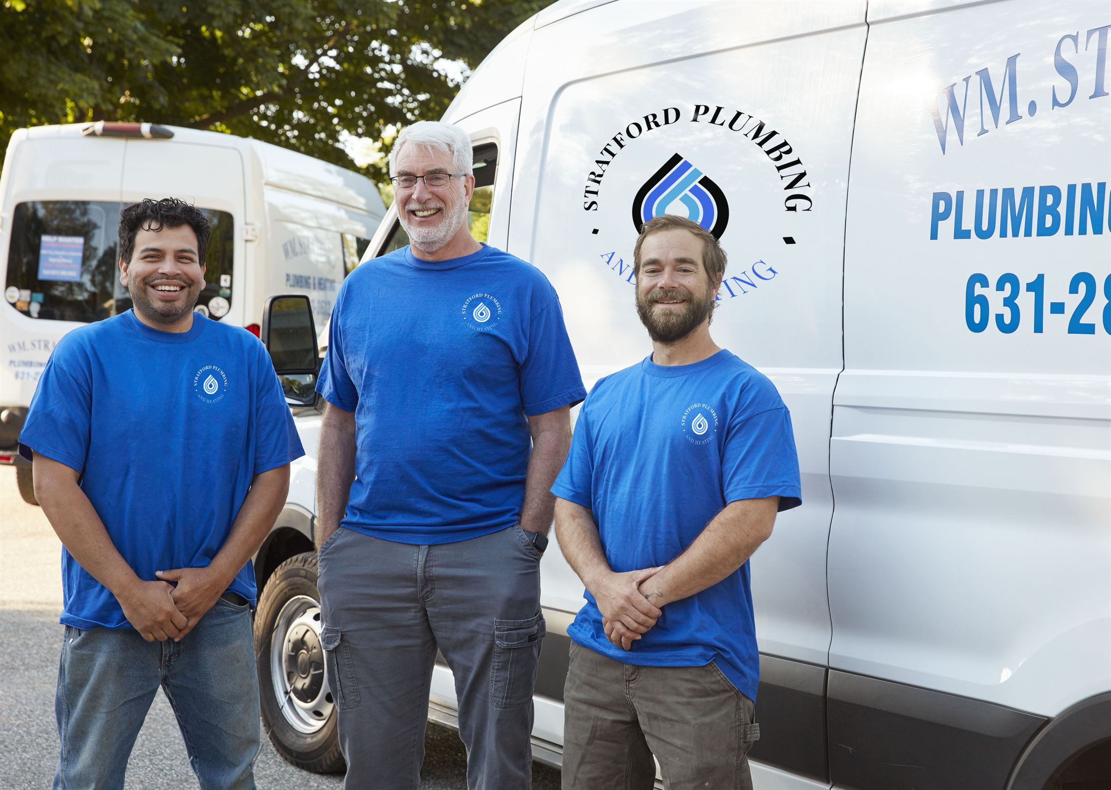 The Stratford Plumbing & Heating crew in front of their branded vans