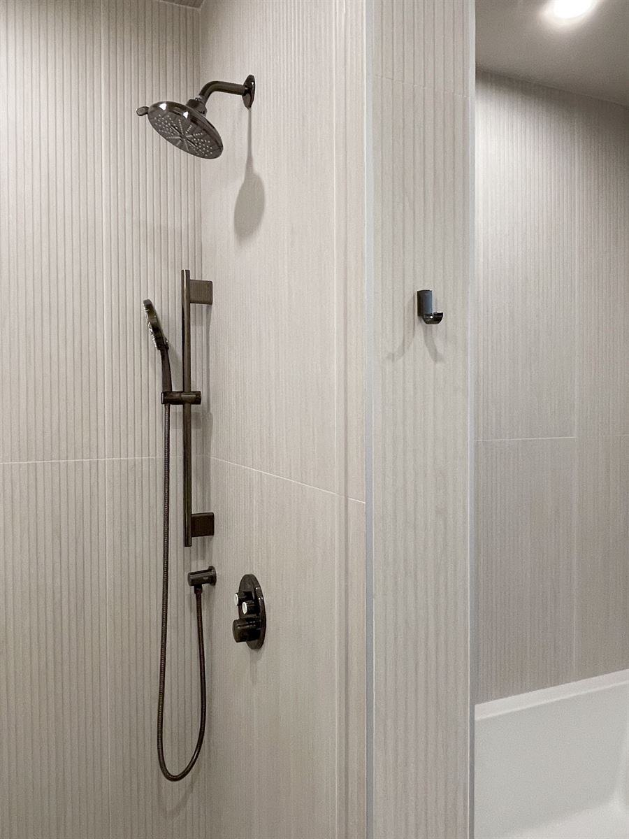 Walk-in shower with bronze rainfall head and handheld
