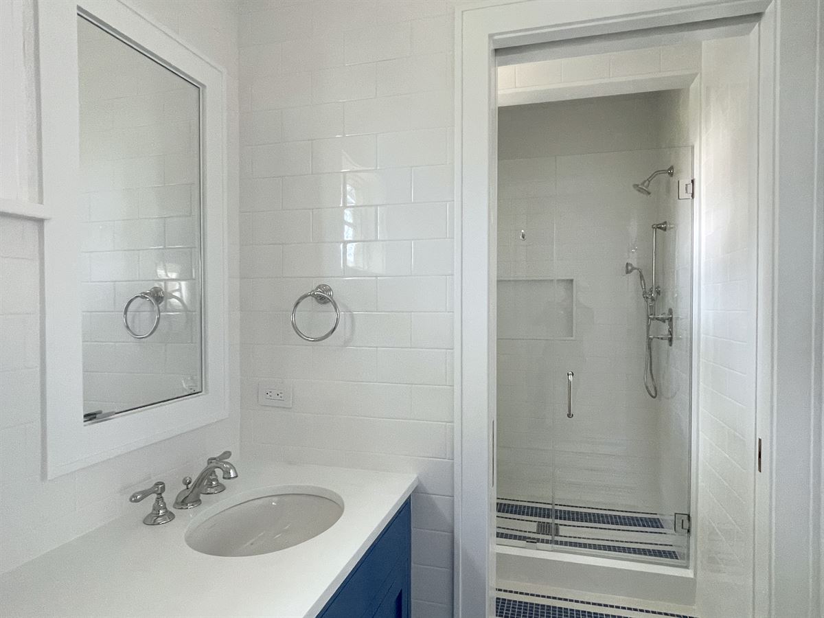 Blue and white bathroom with sink and shower