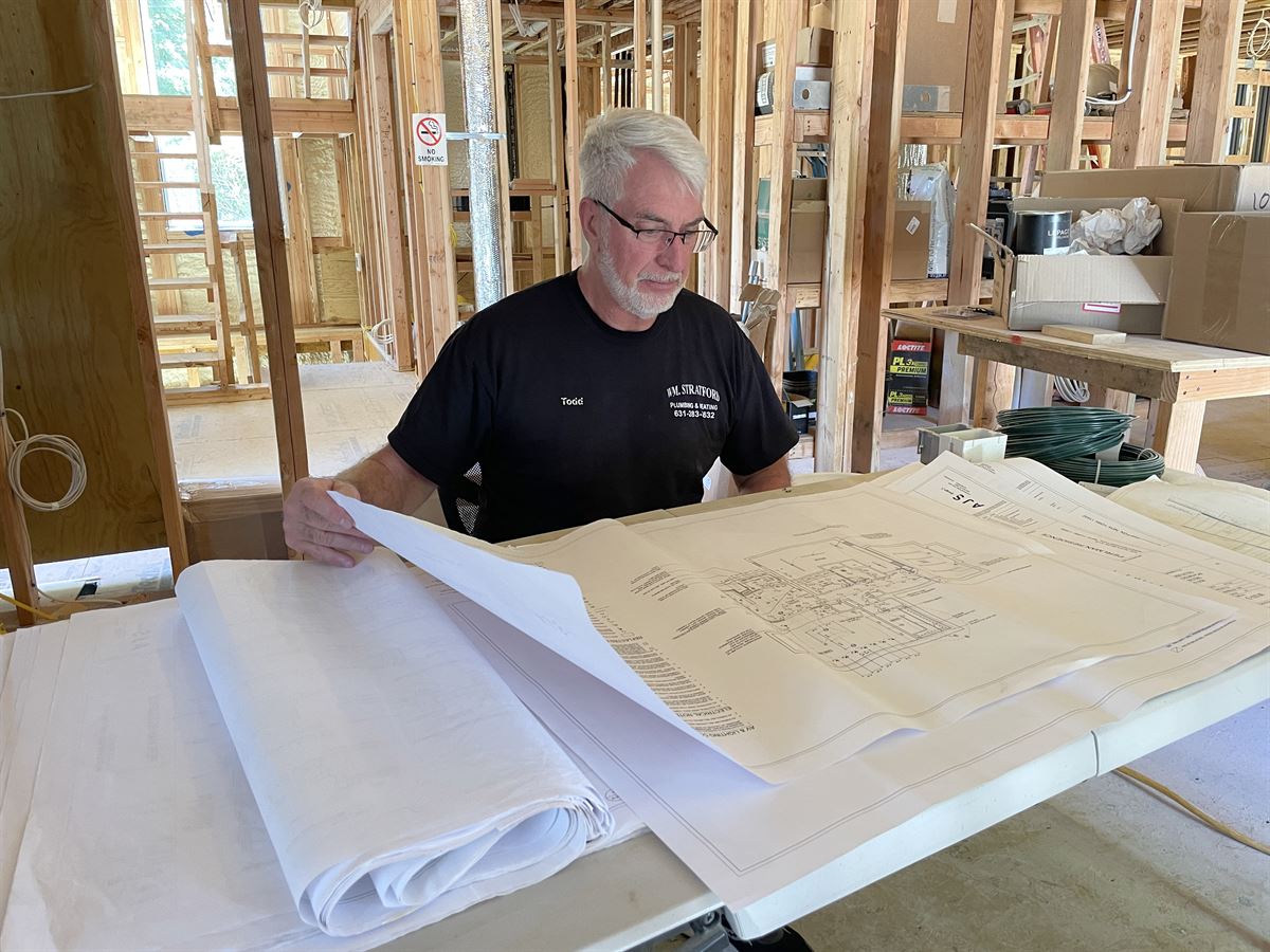 Todd reviewing blueprints at a new construction site