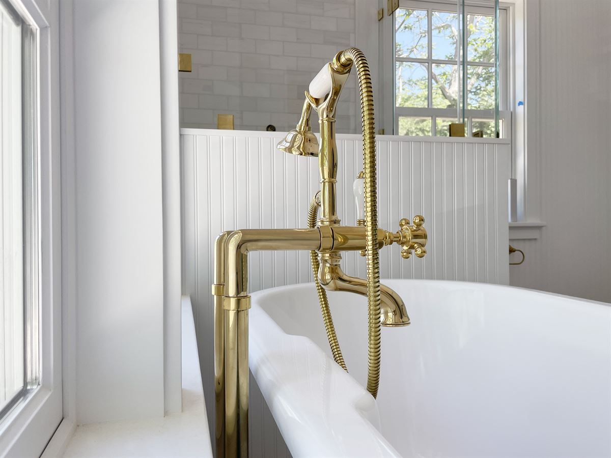 Close-up of brass floor-mount tub filler